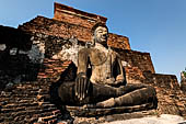 Thailand, Old Sukhothai - Wat Mahathat, square-based, multi-layered chedi with statues of seated Buddha at each side, stucco figures of lions and elephants decorate the base. 